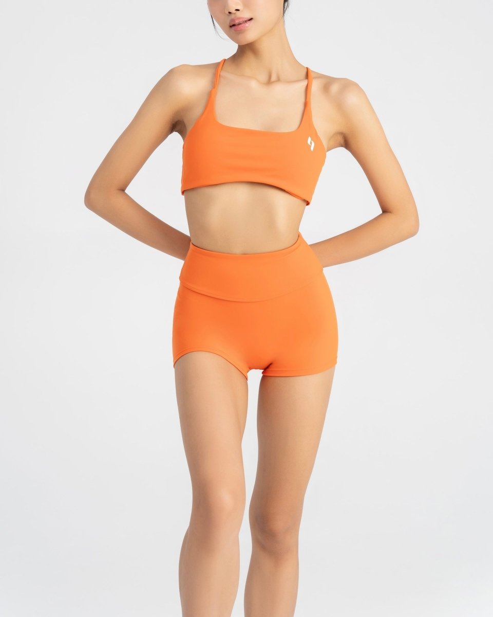 close up front side of women's sports bra and biker short in orange