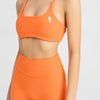 close up front side of women's sports bra in orange