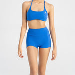 close up front side of women's sports bra and biker short in blue